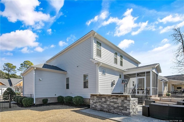 view of side of property with a sunroom, a patio area, fence, and outdoor lounge area