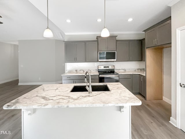 kitchen with stainless steel appliances, gray cabinets, a sink, and decorative backsplash