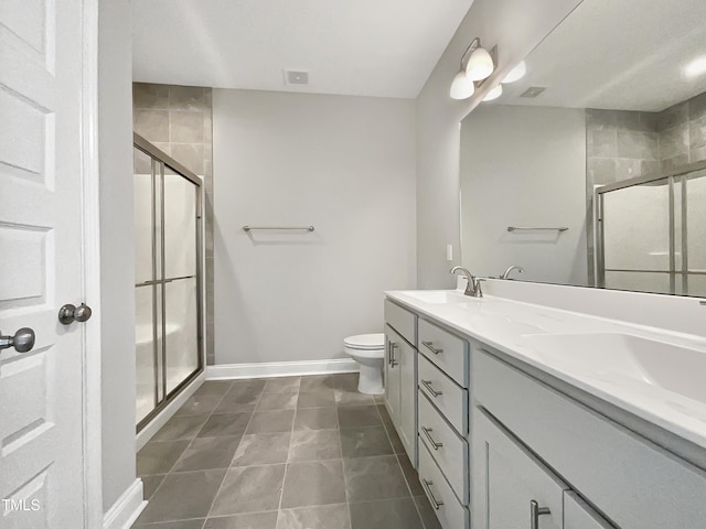 bathroom featuring a sink, a shower stall, baseboards, and double vanity