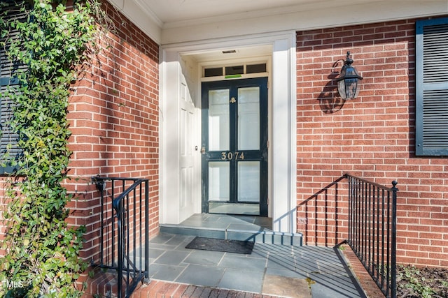 doorway to property featuring brick siding