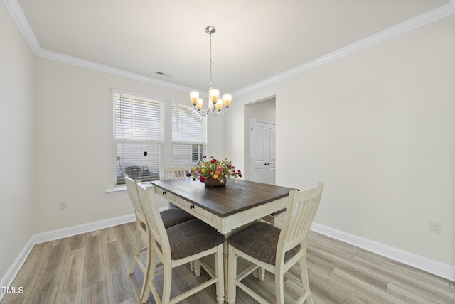 dining room featuring visible vents, baseboards, a chandelier, light wood-type flooring, and ornamental molding