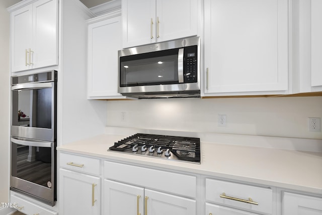 kitchen featuring white cabinetry, stainless steel appliances, and light countertops