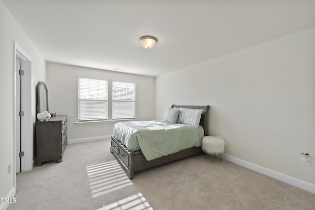 bedroom featuring visible vents, light colored carpet, and baseboards