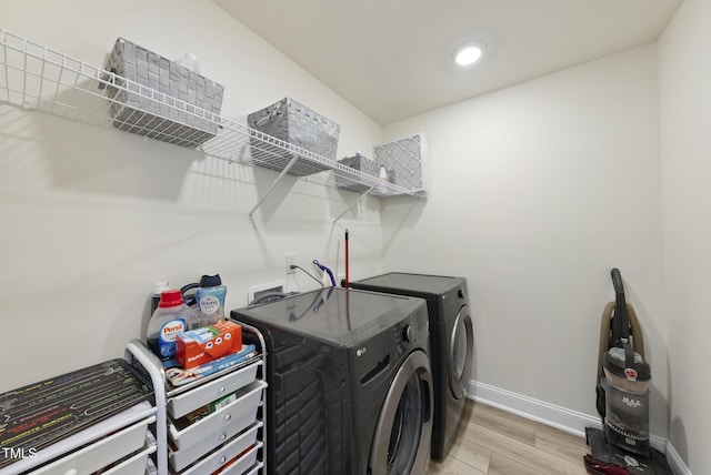 laundry area with washer and clothes dryer, recessed lighting, light wood-style floors, baseboards, and laundry area