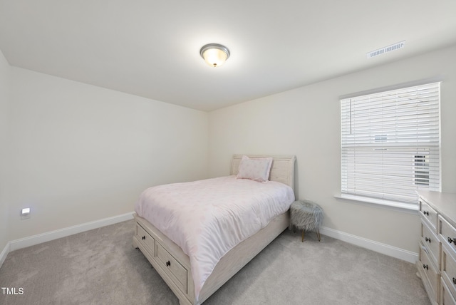 bedroom with light carpet, visible vents, and baseboards