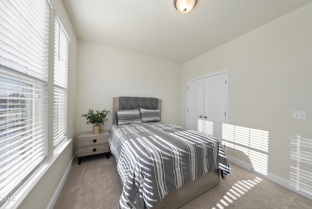 bedroom with a closet, carpet flooring, and baseboards