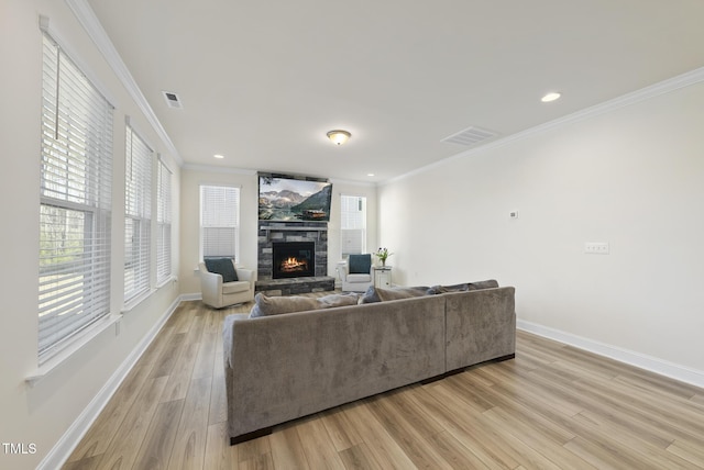 living area with a fireplace, light wood-type flooring, and ornamental molding