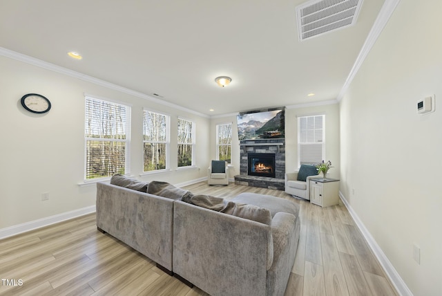 living area with visible vents, light wood-style flooring, ornamental molding, a fireplace, and baseboards