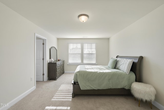 bedroom featuring light colored carpet and baseboards