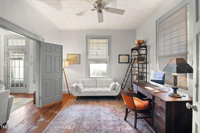 office area with hardwood / wood-style flooring, baseboards, ornamental molding, and ceiling fan