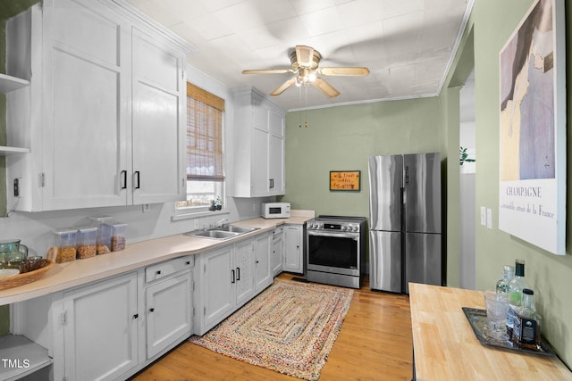 kitchen with appliances with stainless steel finishes, white cabinets, a sink, and open shelves