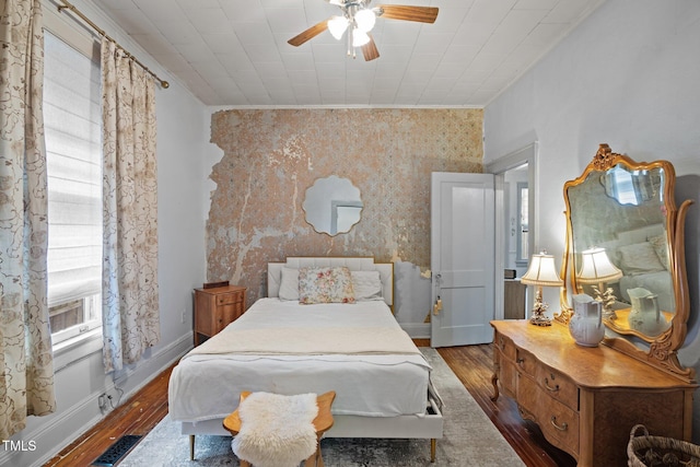 bedroom featuring wallpapered walls, baseboards, visible vents, ornamental molding, and wood finished floors