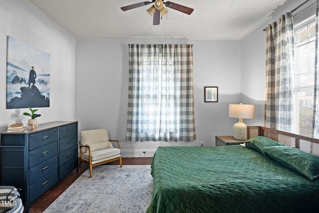 bedroom featuring ornamental molding, dark wood-style flooring, and ceiling fan