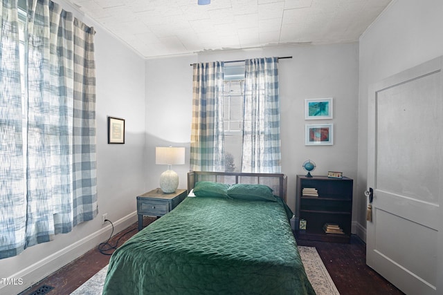 bedroom with baseboards and wood finished floors