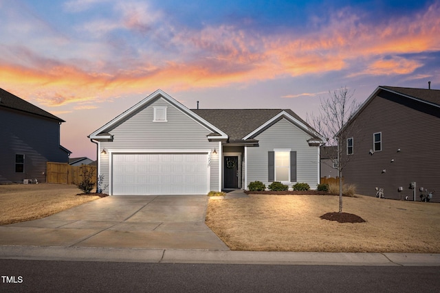 view of front facade featuring a garage, driveway, and fence