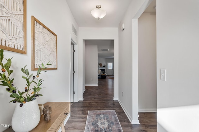 corridor with wood finished floors, visible vents, and baseboards