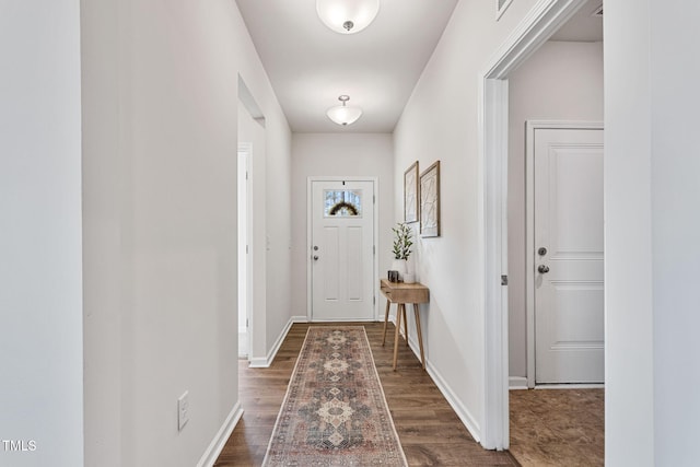 doorway to outside with wood finished floors and baseboards