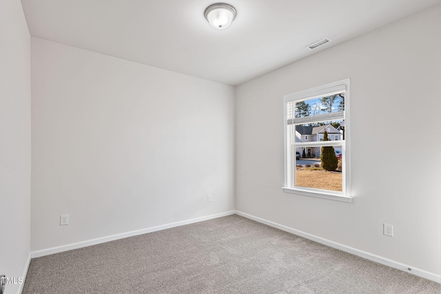 carpeted empty room featuring visible vents and baseboards