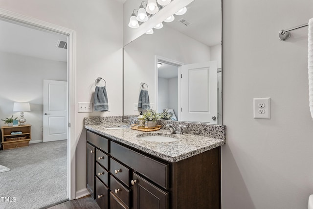 bathroom with visible vents, a sink, and double vanity