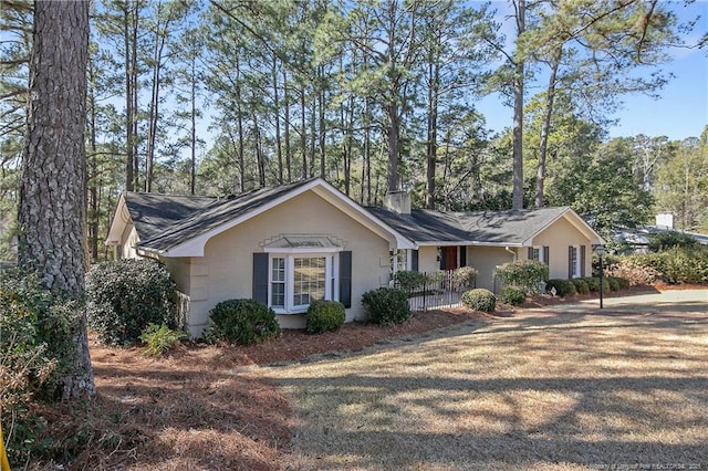 single story home featuring a chimney and stucco siding