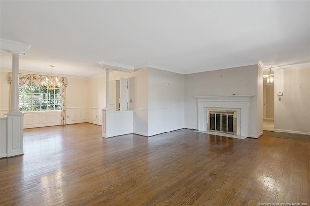 unfurnished living room with ornamental molding, wood finished floors, a fireplace with flush hearth, and decorative columns