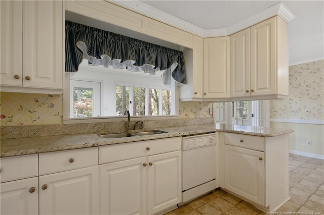 kitchen with light stone counters, white dishwasher, a sink, wainscoting, and wallpapered walls