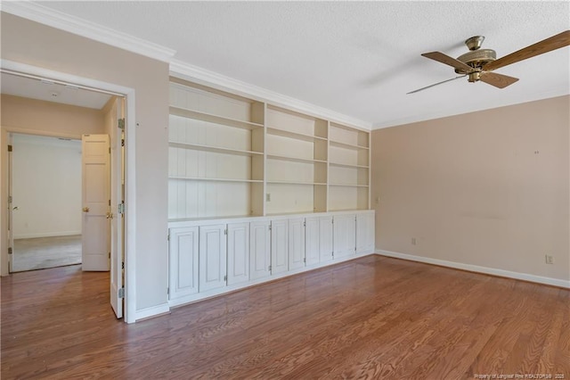 unfurnished room featuring ceiling fan, wood finished floors, and baseboards