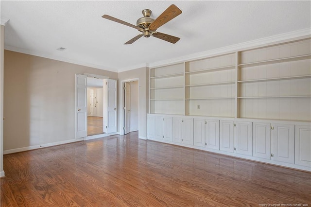 interior space with built in features, baseboards, a ceiling fan, ornamental molding, and wood finished floors