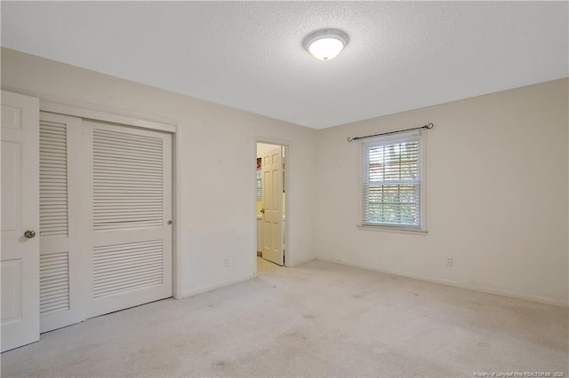 unfurnished bedroom with a closet, carpet flooring, and a textured ceiling