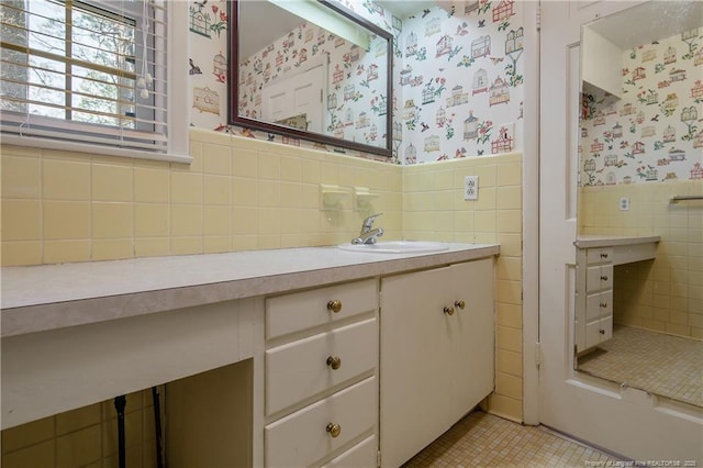 bathroom featuring tile walls, wallpapered walls, wainscoting, vanity, and tile patterned floors