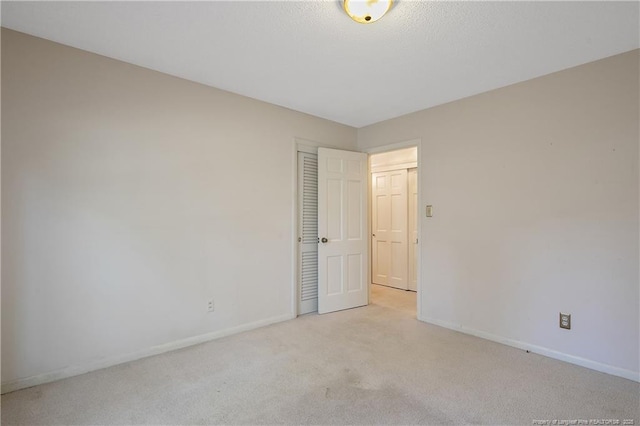 unfurnished room with carpet floors and baseboards