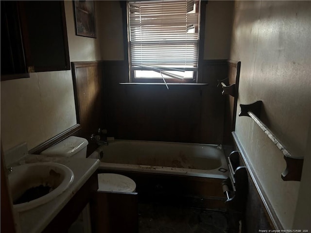 bathroom with toilet, a bathtub, and vanity