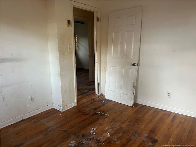 empty room featuring hardwood / wood-style flooring and baseboards