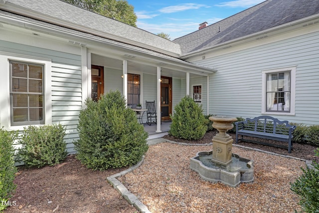 property entrance with a shingled roof and a porch