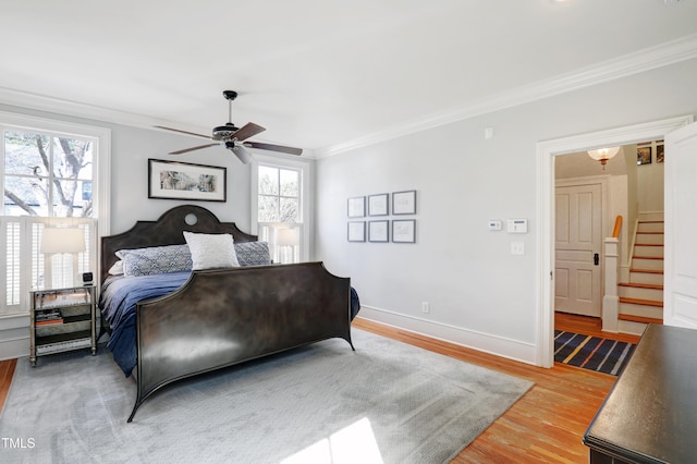 bedroom featuring baseboards, ceiling fan, light wood-style floors, and crown molding