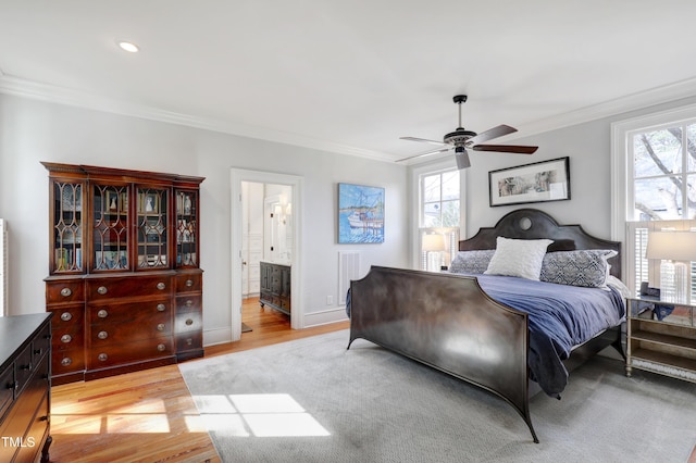 bedroom featuring light wood finished floors, multiple windows, and crown molding