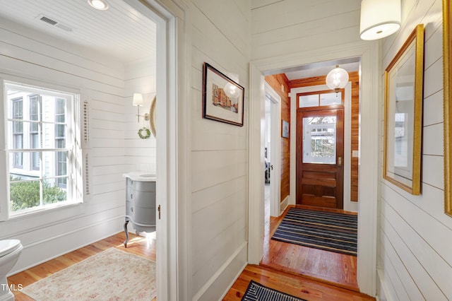 interior space featuring wood walls, visible vents, and wood finished floors