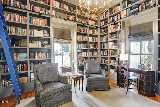 living area with wall of books and a chandelier