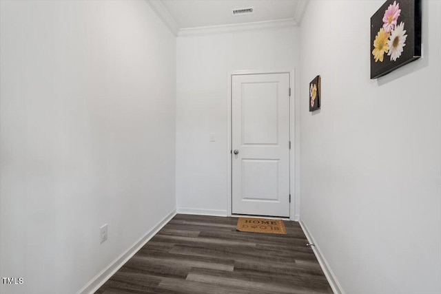 hall featuring dark wood-style floors, ornamental molding, visible vents, and baseboards