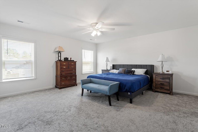 carpeted bedroom featuring a ceiling fan, visible vents, and baseboards