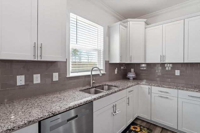 kitchen with a sink, white cabinets, dishwasher, tasteful backsplash, and crown molding