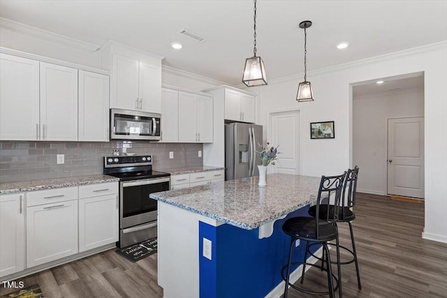 kitchen featuring stainless steel appliances, dark wood-type flooring, a kitchen island, visible vents, and decorative backsplash