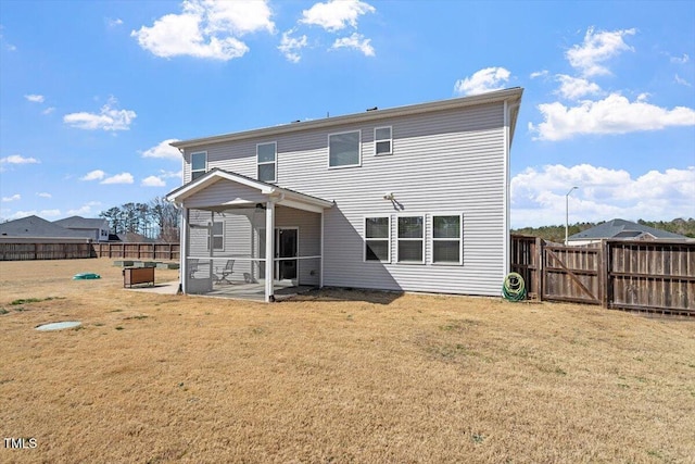 rear view of house with a patio area, a fenced backyard, a gate, and a yard