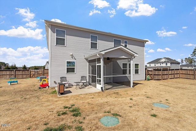 back of property with a sunroom, a fenced backyard, a patio area, and a yard