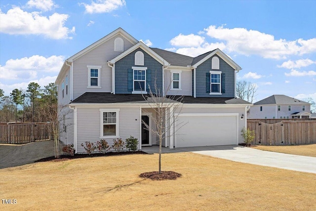 traditional-style home with a front yard, fence, driveway, and an attached garage