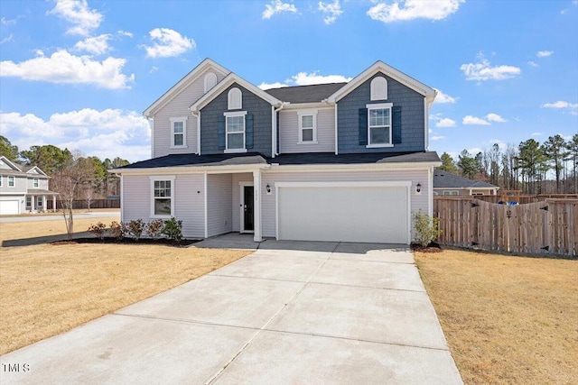 view of front of property featuring a garage, driveway, fence, and a front lawn