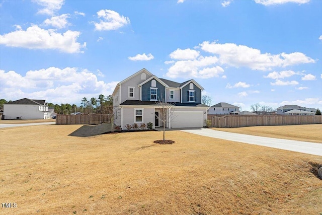 traditional-style home with a garage, concrete driveway, fence, and a front lawn