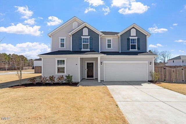 view of front of home with an attached garage, fence, concrete driveway, and a front yard