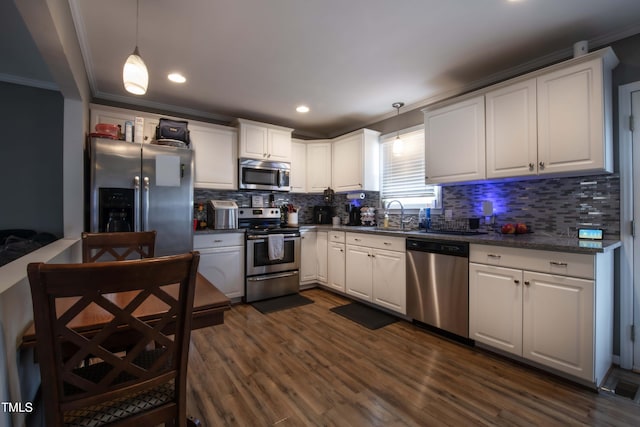 kitchen featuring stainless steel appliances, dark countertops, and white cabinetry