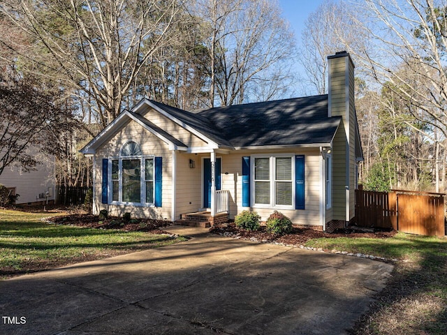 view of front of house featuring a chimney and fence